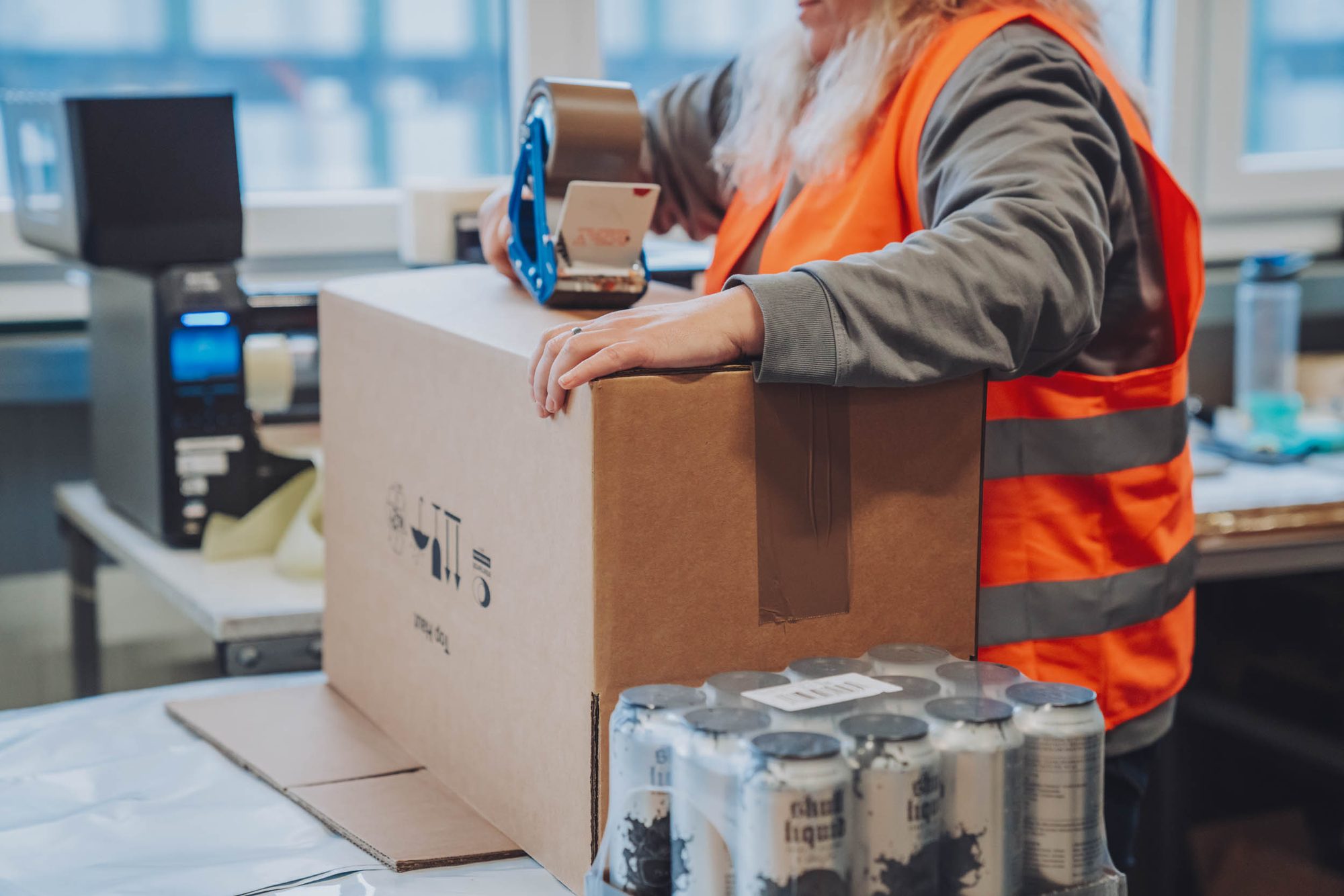 Packing and sealing a shipping carton in dispatch