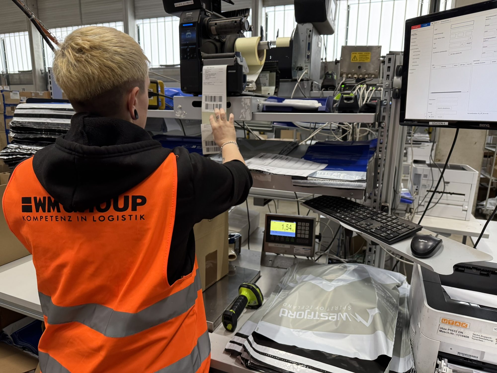 WM GROUP employee labelling a parcel at the shipping station