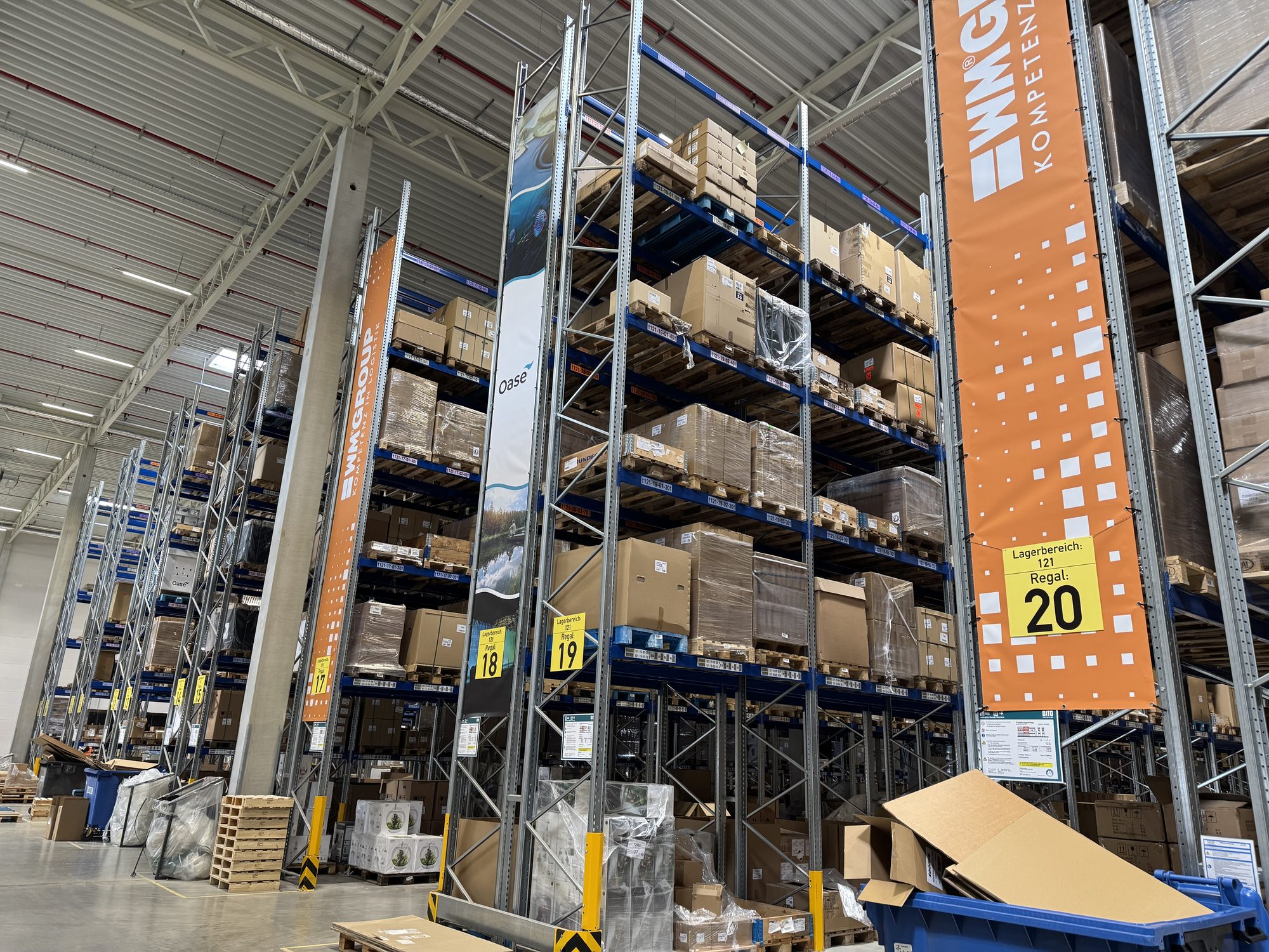WM GROUP high-bay warehouse with competence-centre banners