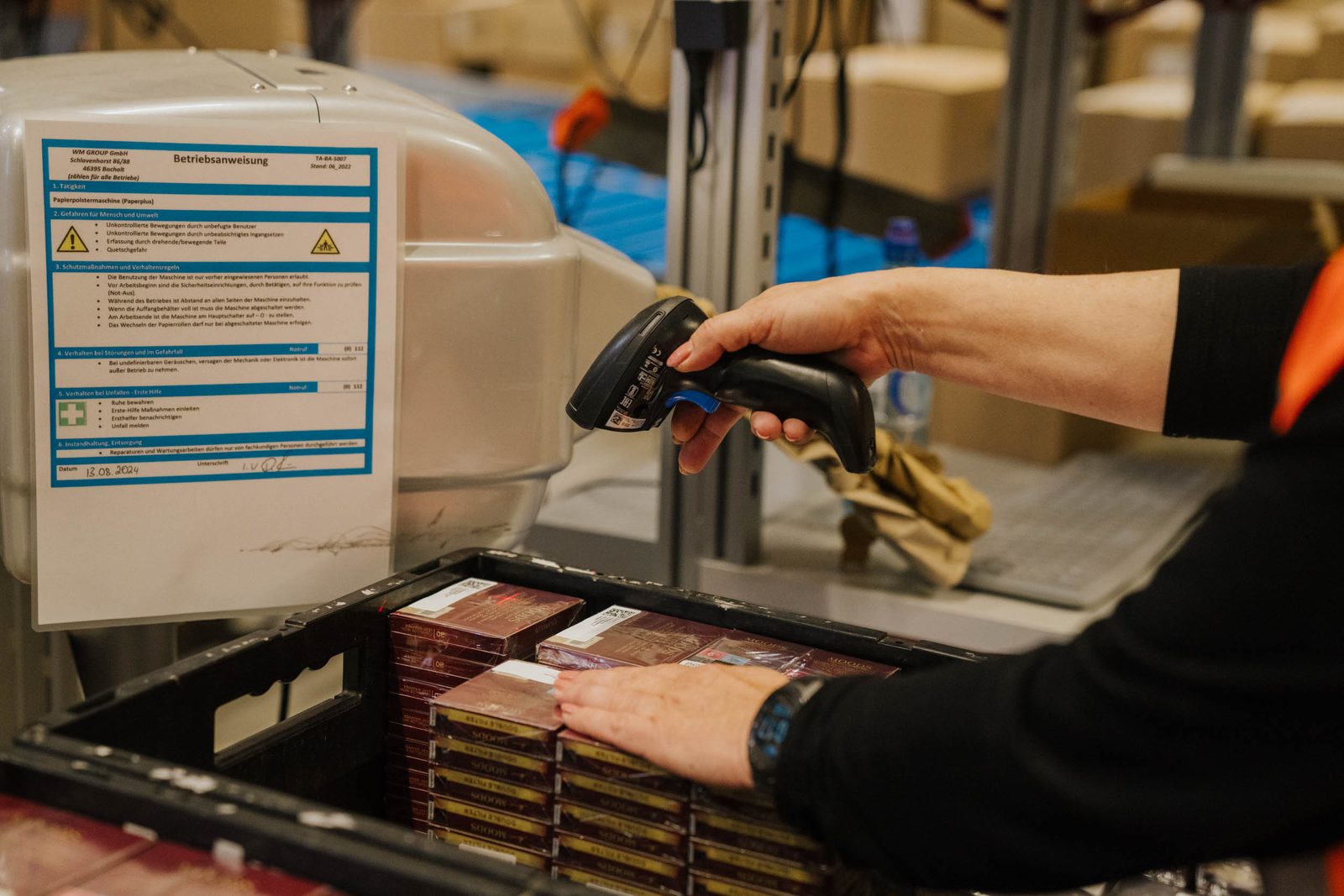 A handheld scanner reading the label on an outer carton.