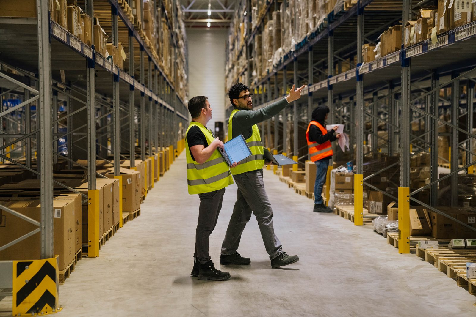 Two colleagues checking stock in the aisle on a tablet.