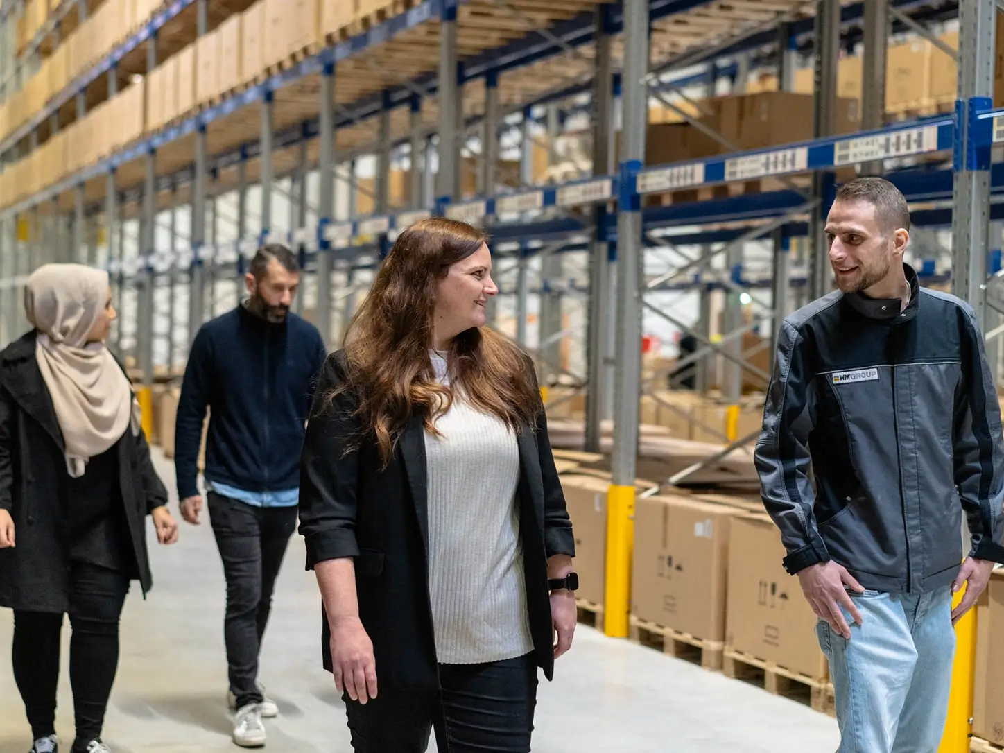 Führungskraft der WM GROUP im Austausch mit Mitarbeitenden in einem Logistiklager